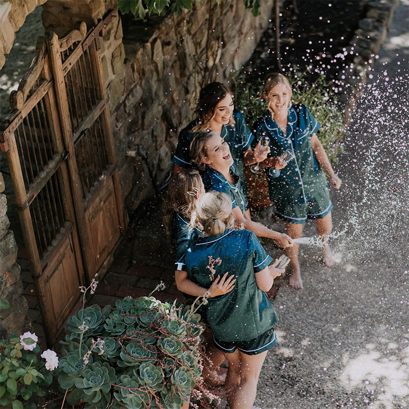 Young women being doused in bubbly spilling from a bottle